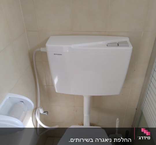 מיכל הדחה לבן עם צינור מים מחובר